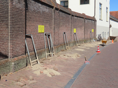 850132 Afbeelding van het verwijderen van fietsenrekken bij de buitenmuur van Grand Hotel Karel V aan de Springweg te ...